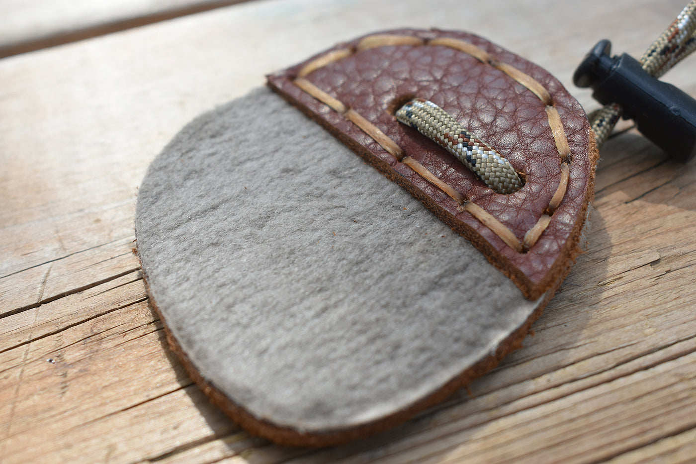 Standing Wolf Archery Finger Tab made with beaver, bison and moose leather, a finger loop is attached with a locking cord clip.